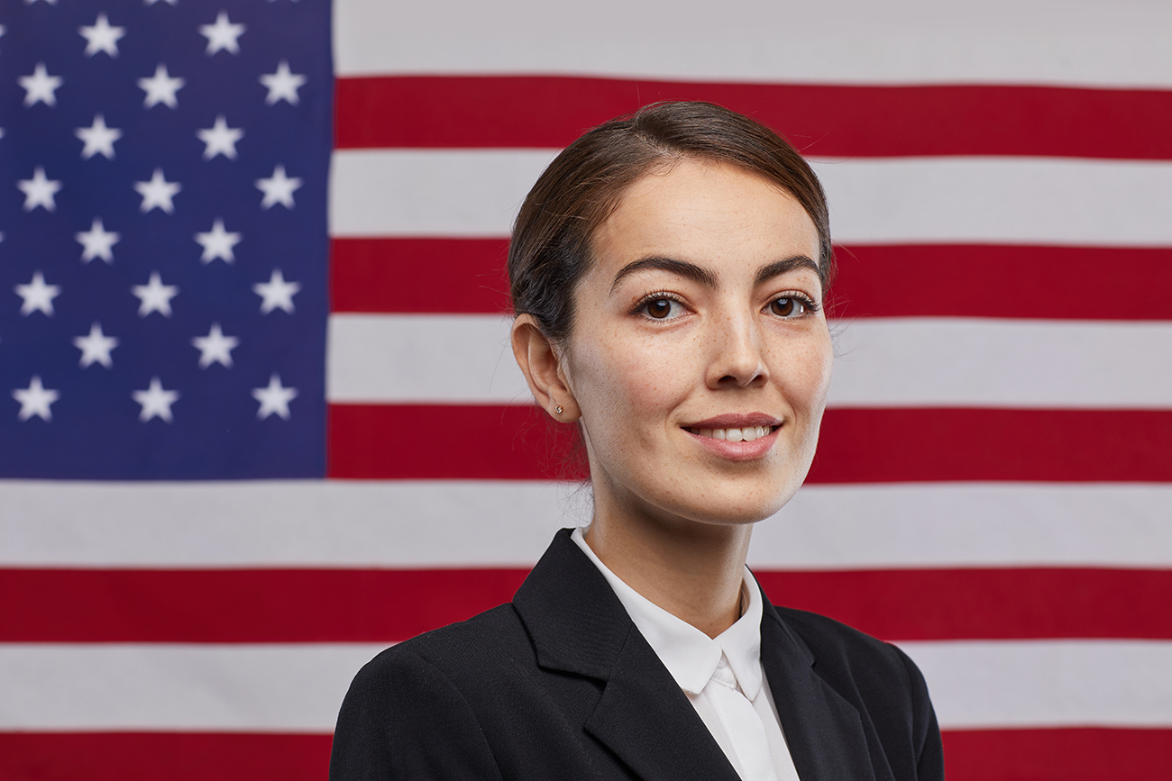 Professional woman standing in front of American flag